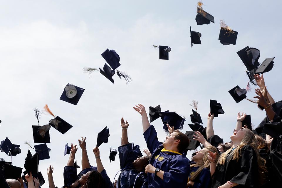 Student throwing graduation hats in the air